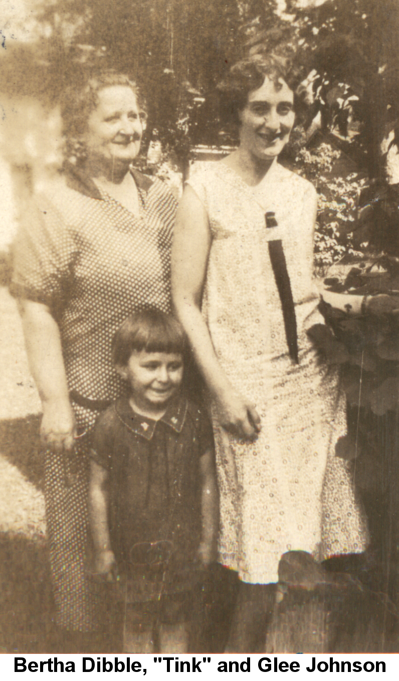 Black and white photo of Bertha Dibble smiling in a polka-dot dress, Glee Johnson smiling in a white flowered dress, and Tink, about four years old, standing between them grinning.